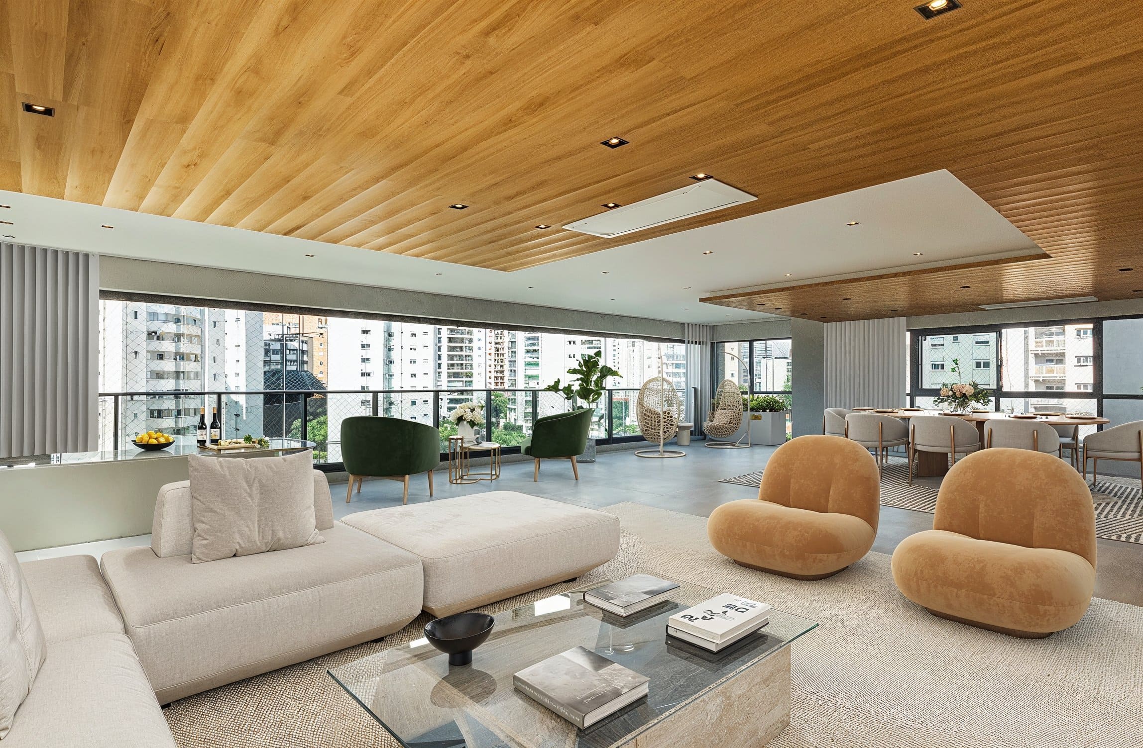 Sala de estar espaçosa em um imóvel de alto padrão, com móveis modernos, teto de madeira e ampla varanda com vista para a cidade. O ambiente integra conforto e sofisticação, ideal para viver.